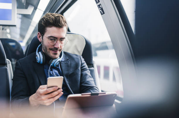 Homme dans un transport en commun avec une tablette et un téléphone portable